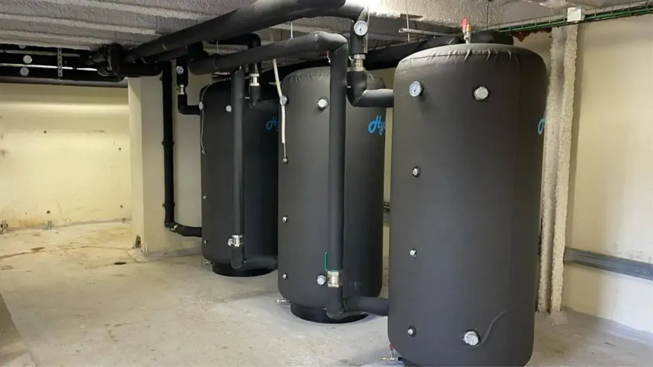 Tres grandes calderas para hoteles, con aislamiento negro y tuberías conectadas, listas para proveer agua caliente.
