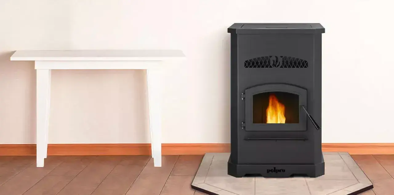 Estufa de pellets negra con fuego encendido. Junto a una mesa blanca. ¡No cae pellet en la estufa, todo limpio y seguro!