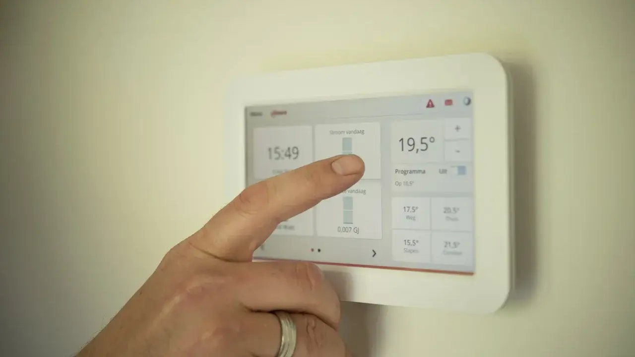Dedo interactúa con un termostato modulante, ajustando la temperatura a 19,5°C.