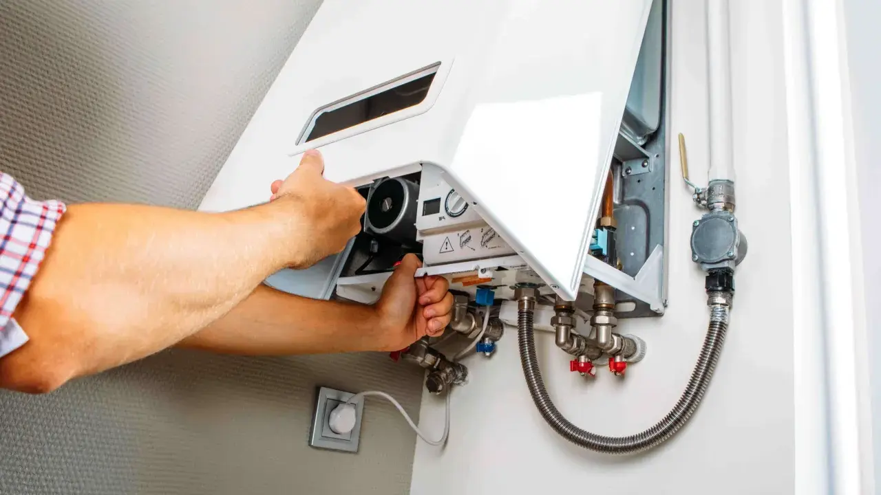 Man checks a gas boiler that won't ignite. He opens the cover to inspect the internal components.