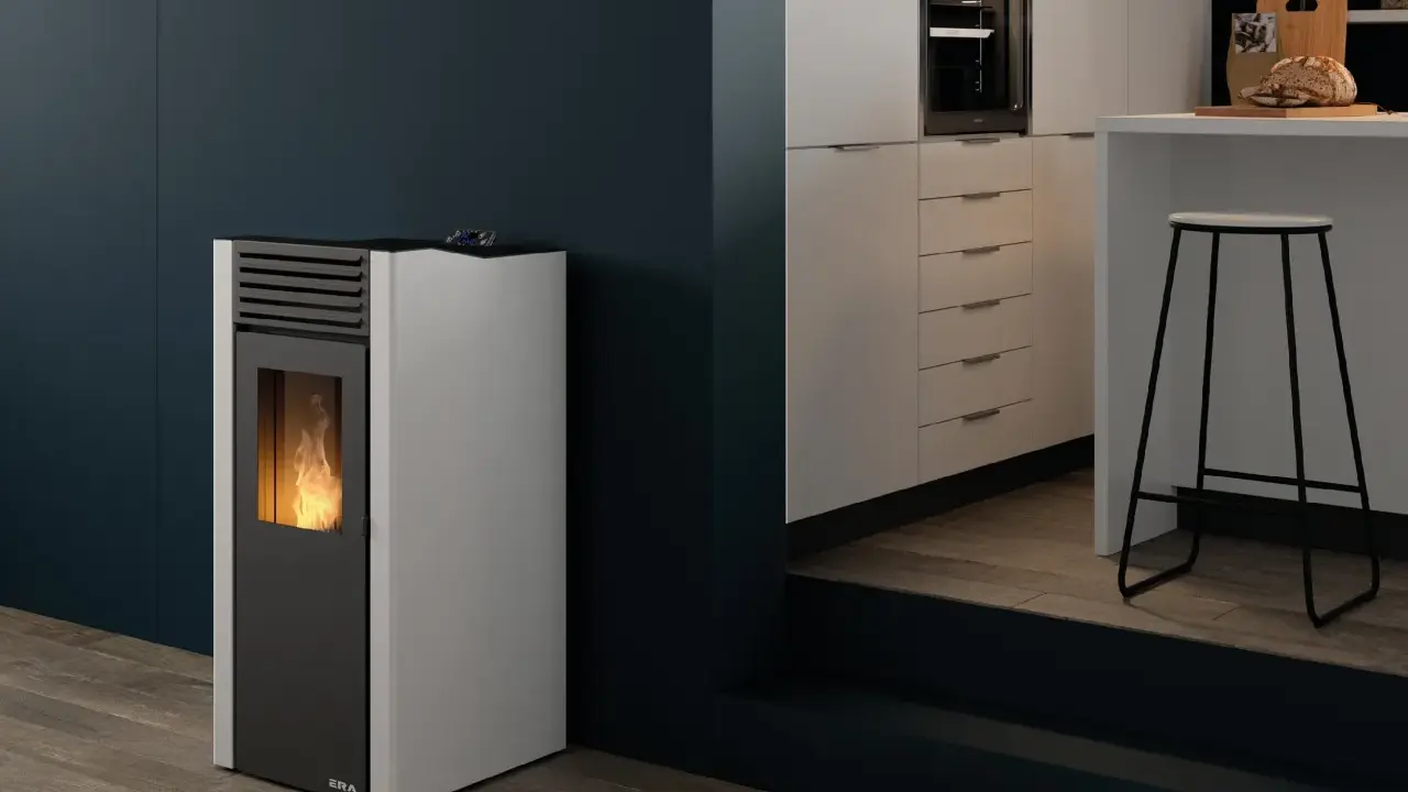 Estufa de pellets sin salida de humos con llama encendida, junto a una barra de cocina moderna.