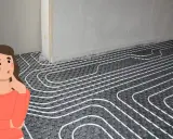 Mujer pensativa ante un suelo radiante con caldera de gasoil.