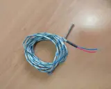 Sonda de temperatura para estufa de pellets, posiblemente indicando un fallo. Cable enrollado con punta metálica y cables rojo y azul.