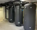 Tres grandes calderas para hoteles, con aislamiento negro y tuberías conectadas, listas para proveer agua caliente.