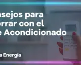 Consejos para reducir el consumo de aire acondicionado. Una mano sostiene un control remoto, mostrando la temperatura.