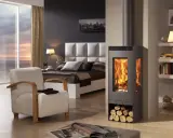 Estufa moderna con leña apilada, mostrando cómo funciona una estufa al quemar madera para calentar la habitación.