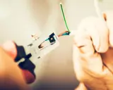 Manos con guantes pelando cables para como cambiar el termostato de la calefacción.
