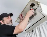 Técnico revisa un aire acondicionado. ¿Cuanto dura un aire acondicionado? El mantenimiento es clave para su longevidad.