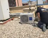 Técnico realizando mantenimiento preventivo de aire acondicionado en una azotea.