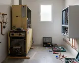 Instalación de aerotermia con fugas de agua. Un técnico repara el sistema, rodeado de herramientas y tuberías de cobre.