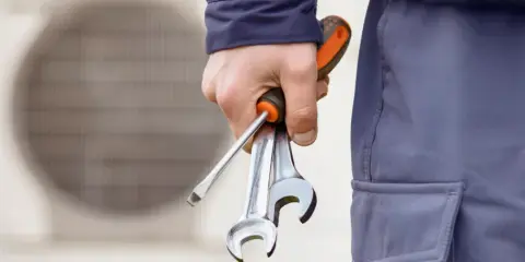 Técnico con herramientas, listo para revisar la vida útil de la bomba de calor.