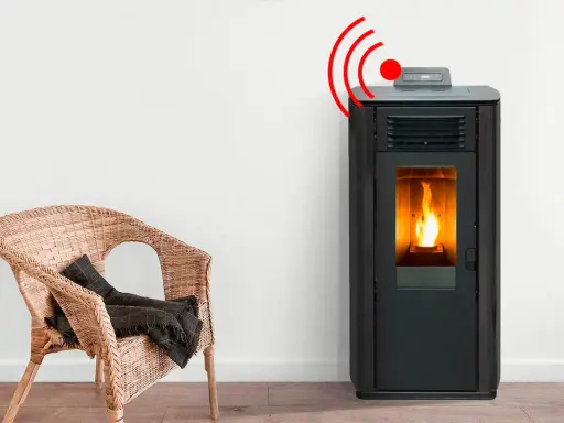 Estufa de pellets con llama encendida y señal de alarma. Junto a una silla de mimbre con manta.