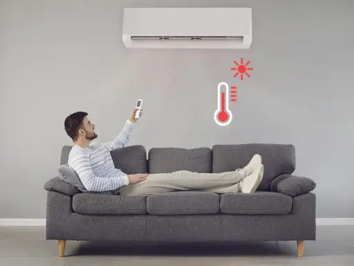 Hombre en sofá con control remoto ajustando el aire acondicionado calefacción. Termómetro rojo indica alta temperatura.