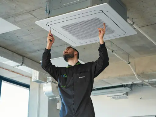 Técnico instala unidad de aire centralizado en el techo.