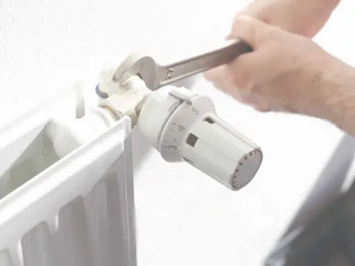 Ajustando el termostato de un radiador. Averigua cuanto cuesta una hora de calefacción de gas natural para optimizar tu consumo.