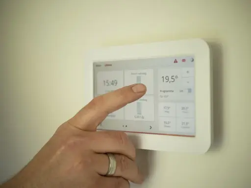 Dedo interactúa con un termostato modulante, ajustando la temperatura a 19,5°C.