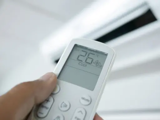 Mando a distancia de aire acondicionado mostrando 26°C en modo "Cool". El modo "Dry" deshumidifica el aire.