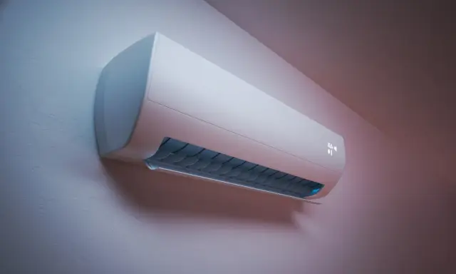 Un moderno aire acondicionado blanco en una pared, con rejillas azules y una pantalla digital. Su funcionamiento es silencioso, con bajos decibelios aire acondicionado.