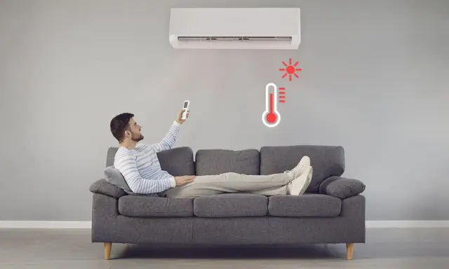 Hombre en sofá con control remoto ajustando el aire acondicionado calefacción. Termómetro rojo indica alta temperatura.