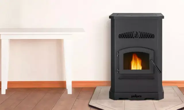 Estufa de pellets negra con fuego encendido. Junto a una mesa blanca. ¡No cae pellet en la estufa, todo limpio y seguro!