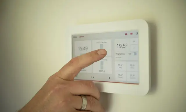 Dedo interactúa con un termostato modulante, ajustando la temperatura a 19,5°C.