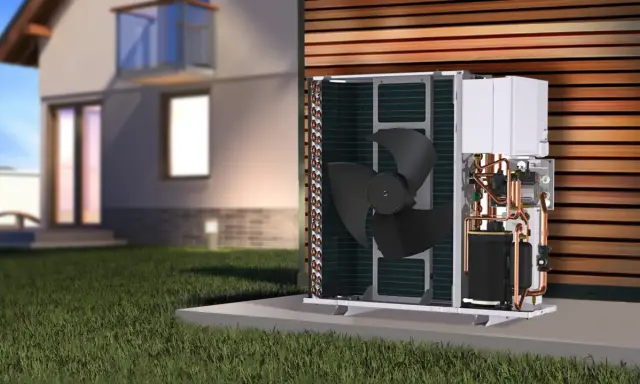 Unidad exterior de bomba de calor por absorción a gas, con componentes internos visibles, junto a una casa moderna.