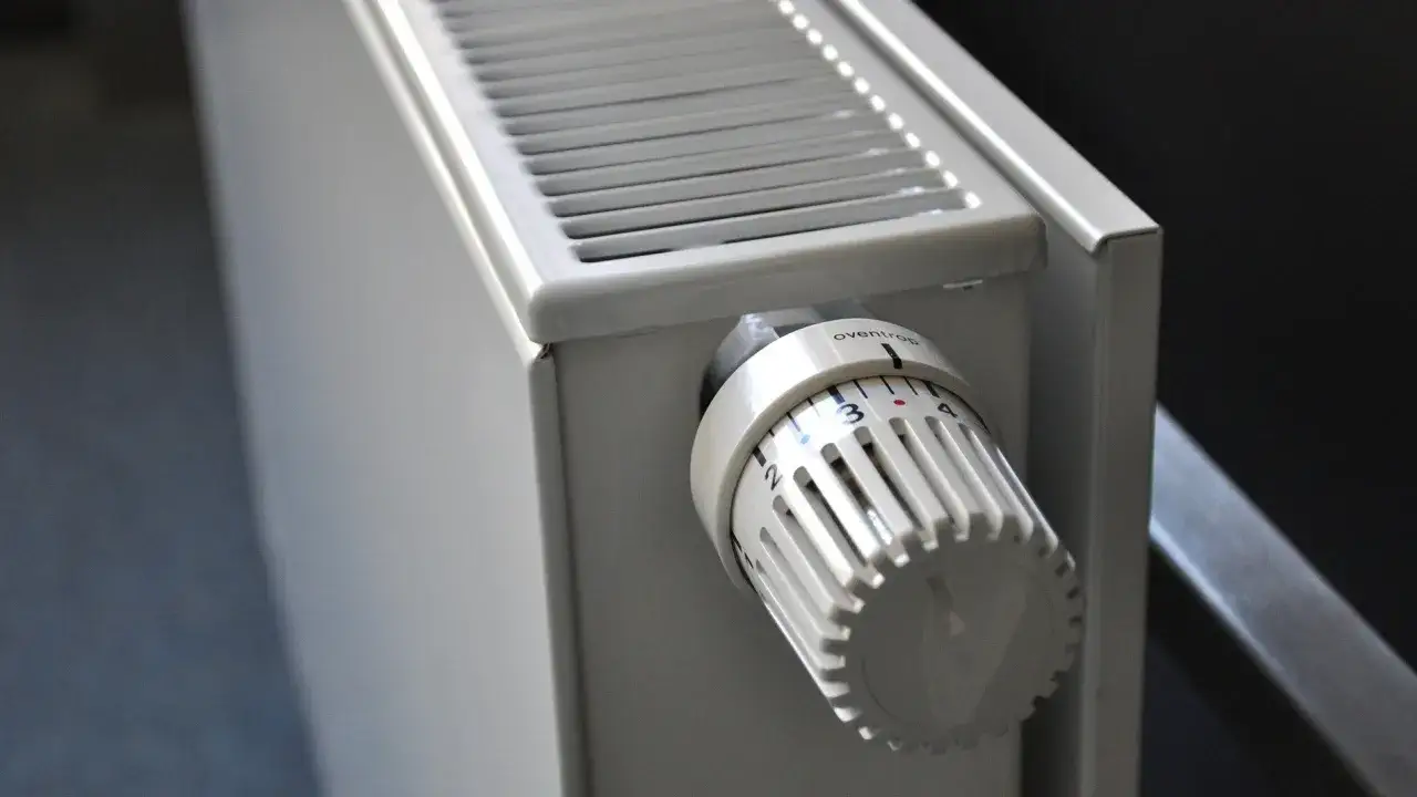 Radiador blanco con termostato ajustable para calefacción sin electricidad.