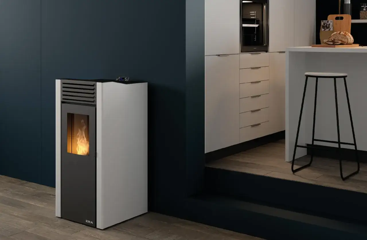 Estufa de pellets sin salida de humos con llama encendida, junto a una barra de cocina moderna.