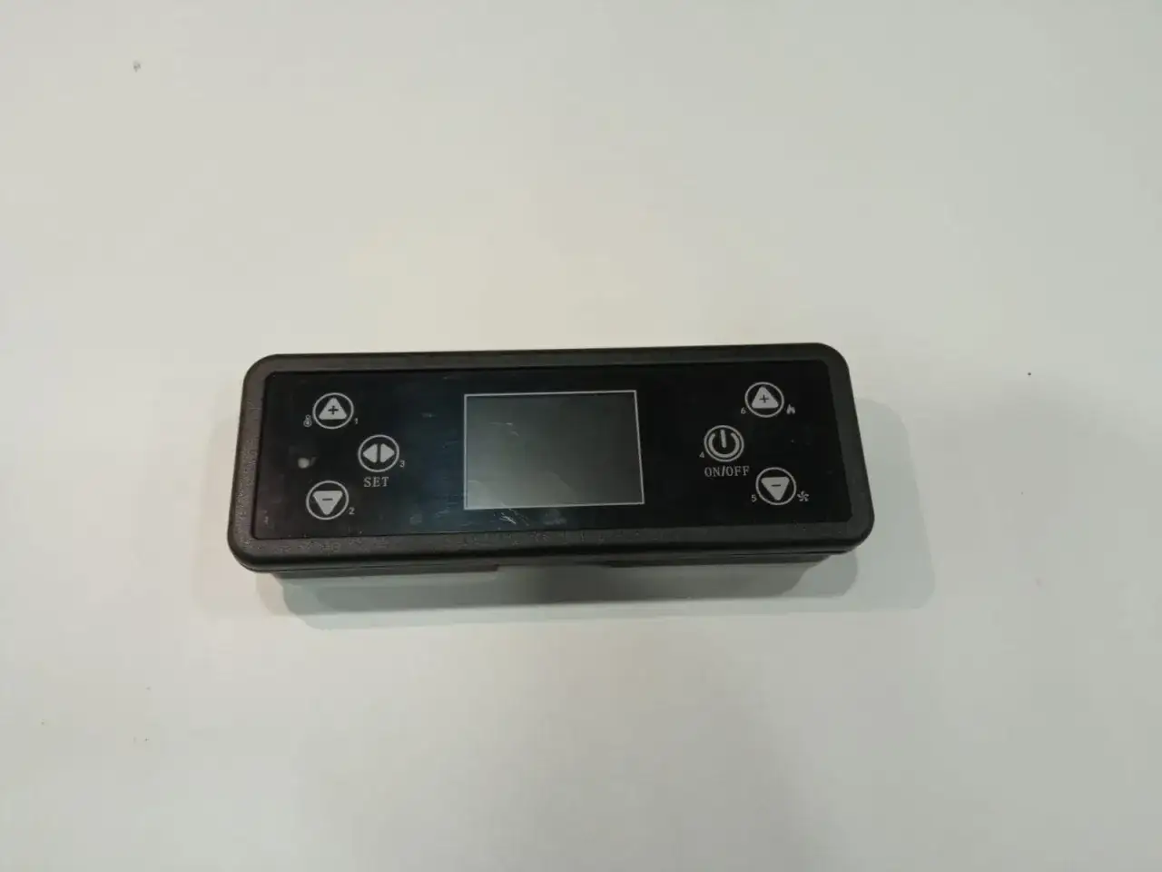 Display de estufa pellet no enciende. Panel de control con pantalla y botones para ajustar temperatura y encendido/apagado.