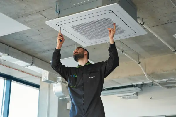 Técnico instala unidad de aire centralizado en el techo.