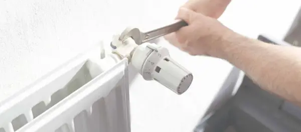 Ajustando el termostato de un radiador. Averigua cuanto cuesta una hora de calefacción de gas natural para optimizar tu consumo.